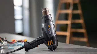 Le pistolet à air chaud et les accessoires sont sur l'établi et prêts à être utilisés