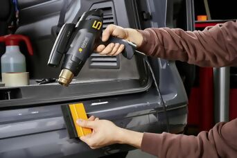 Mithilfe einen Heißluftgerätes, einem Rakel und einem Temperaturscan wird eine Folie auf einem Auto angebracht
