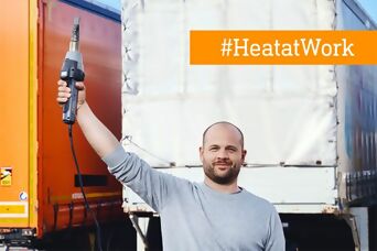 Mann hält stolz sein Heißluftgebläse in die Luft