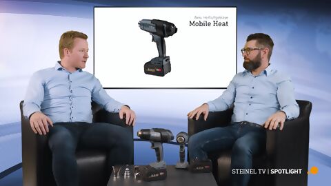 zwei Steinelmitarbeiter sitzen auf dem Sofa und sprechen über die kabellose Heißluft-Serie MobileHeat, die vor ihnen auf dem Tisch steht